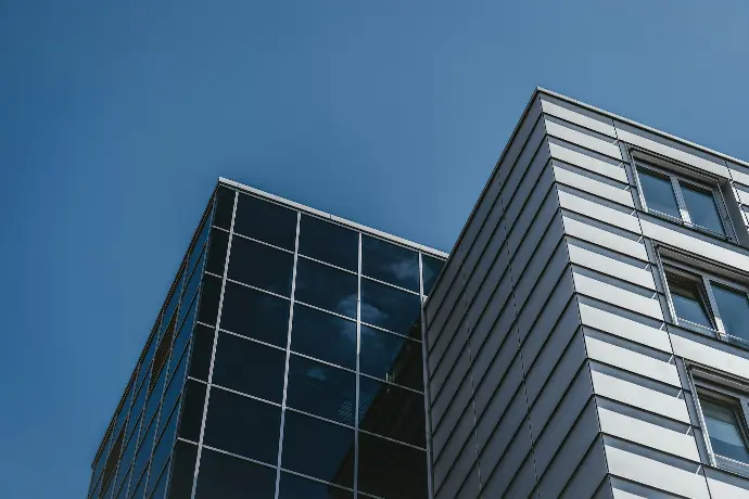 low angle photography of glass walled high rise building under blue sky during daytime